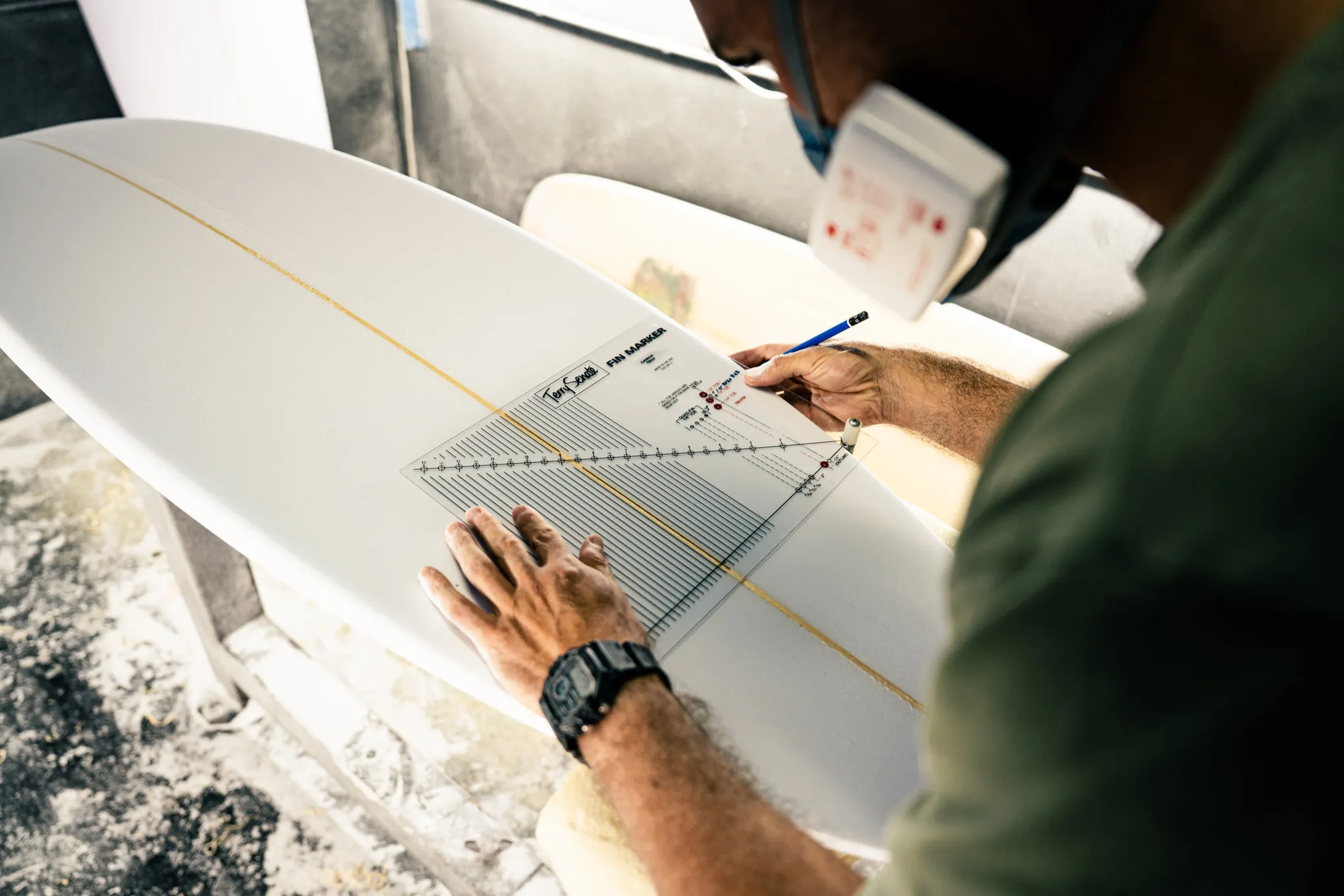 Edu marking the fin positions on a freshly shaped board